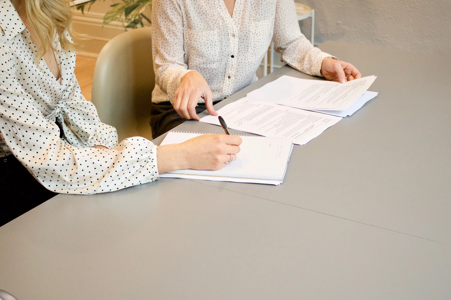 Two people reviewing and marking up printed documents together.