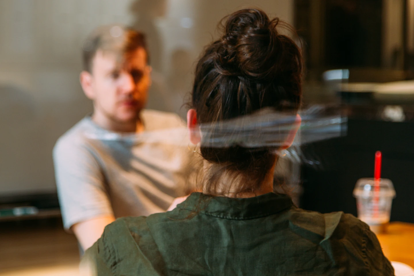 Two people in conversation across a small office table.