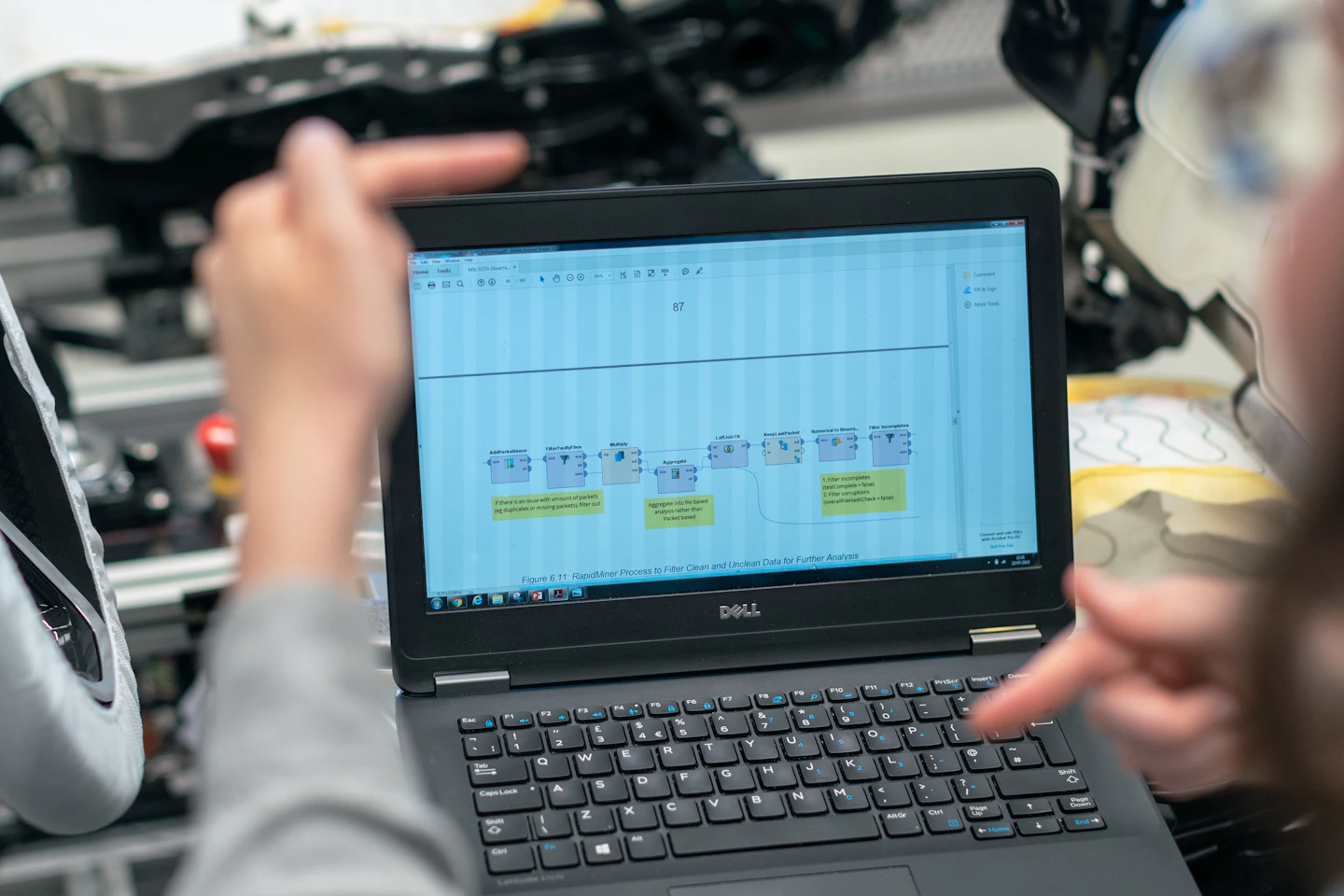 An engineer reviewing technical data on a laptop beside equipment.