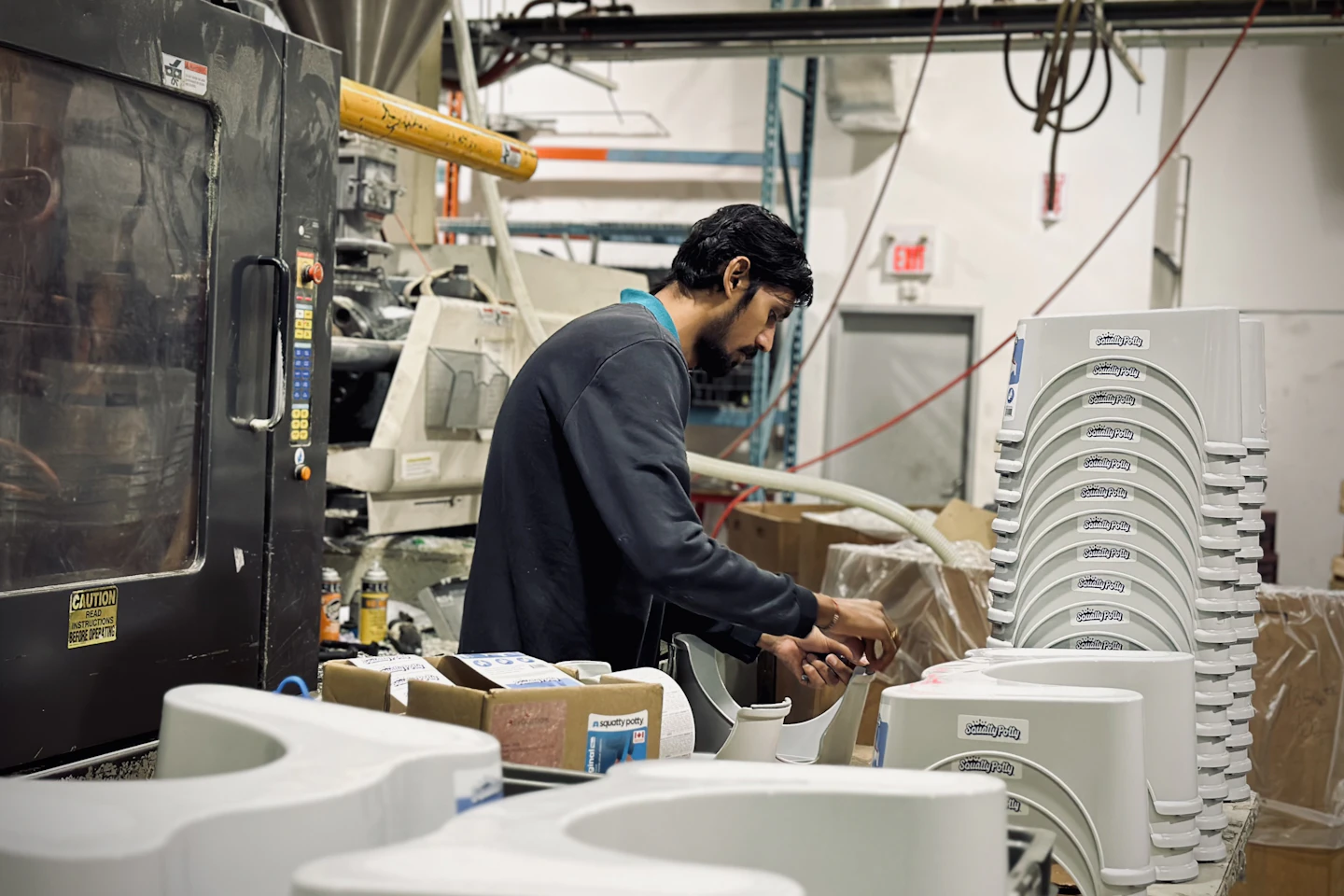 A worker tending a machine on a factory floor.