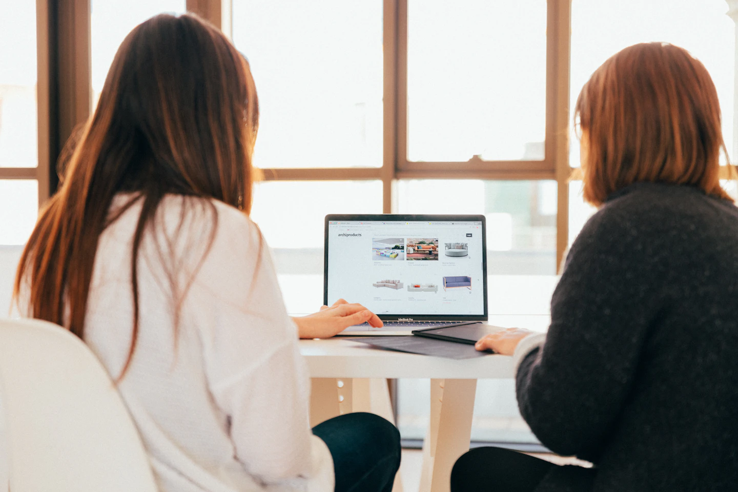 Two colleagues reviewing a website together on a laptop.